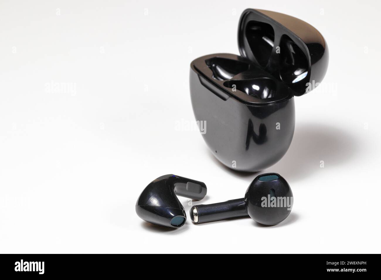 Schwarzer kabelloser bluetooth-Kopfhörer oder -Ohrhörer oder -Kopfhörer, isoliert auf weißem Hintergrund. Stockfoto
