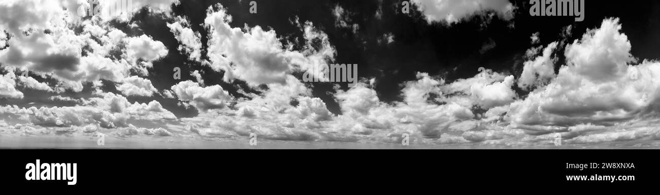 Panoramablick auf den Himmel mit flauschigen Wolken. Schwarz-weiß Stockfoto