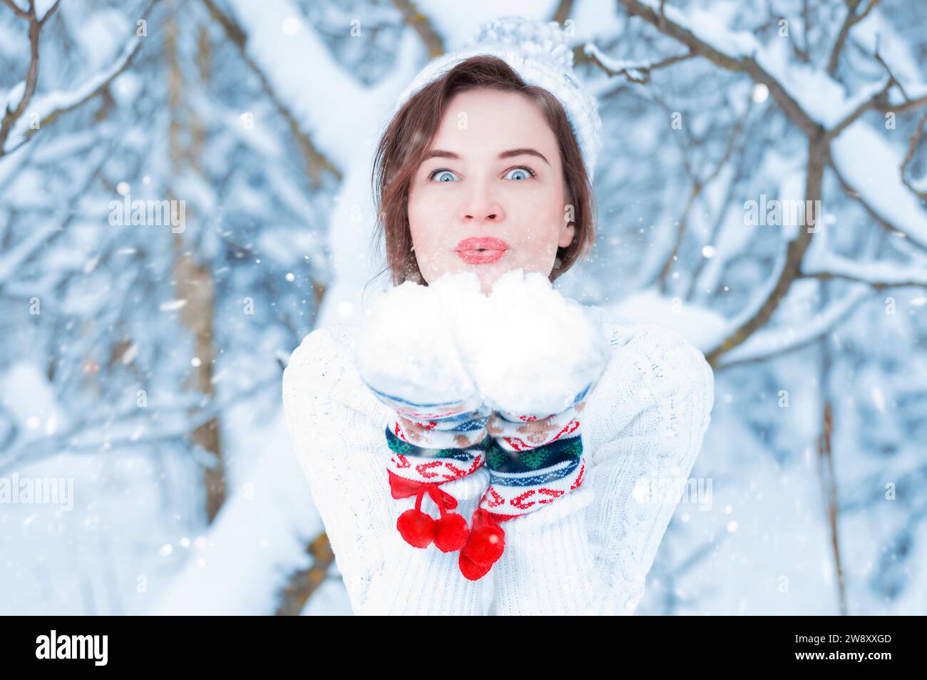Porträt einer schönen Frau vor dem Hintergrund eines Winterwaldes in Silvesterfäustlingen. Konzept von Weihnachten, Winterfeiern, Spaziergängen Stockfoto