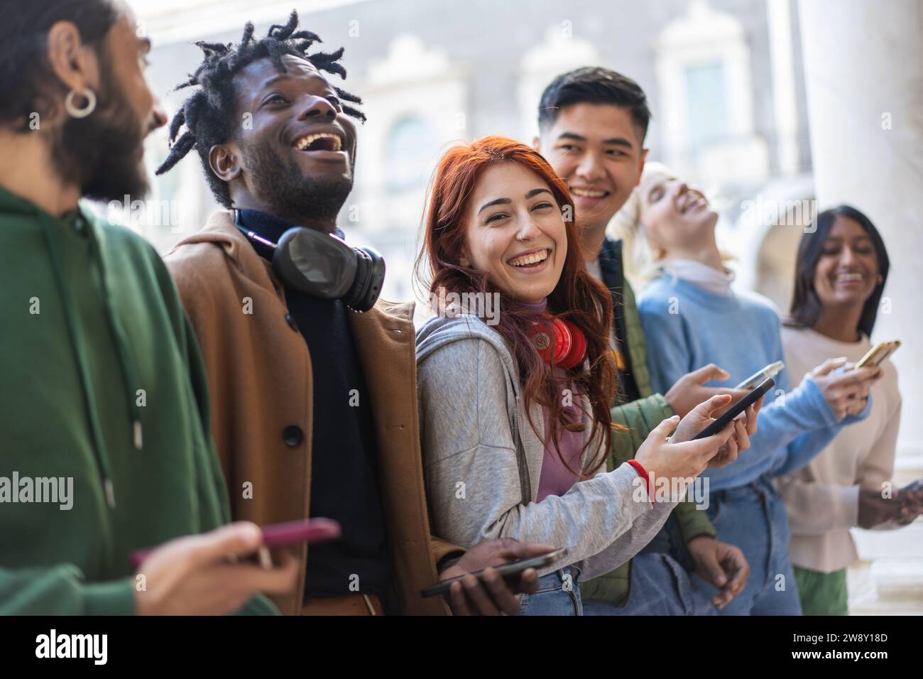 Multikulturelle Freunde lachen und unterhalten sich in einer Stadt und verbringen einen fröhlichen Tag. Stockfoto