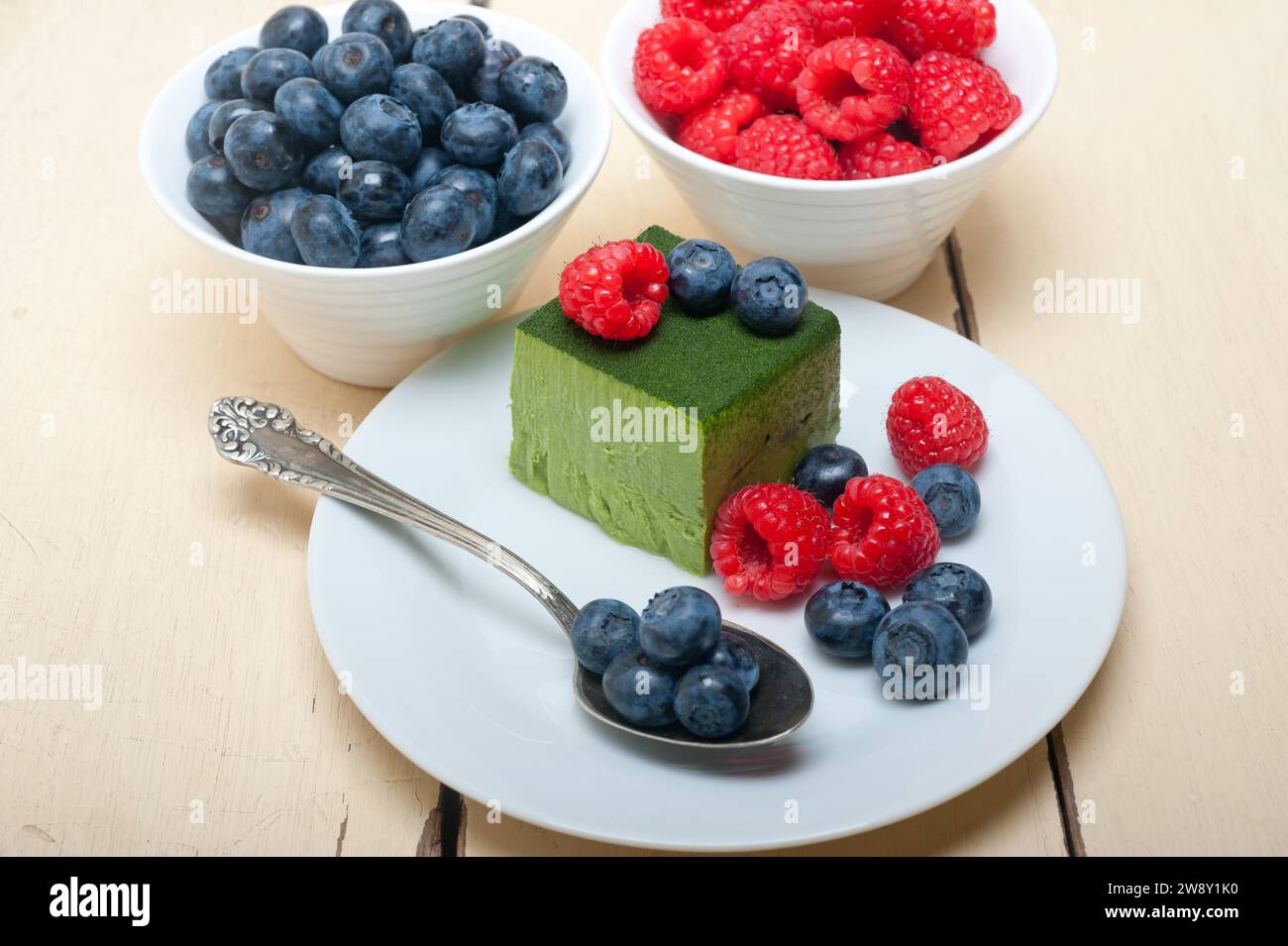 Grüner Tee Matcha Mousse Kuchen mit Himbeeren und Heidelbeeren oben, Lebensmittelfotografie, Lebensmittelfotografie Stockfoto