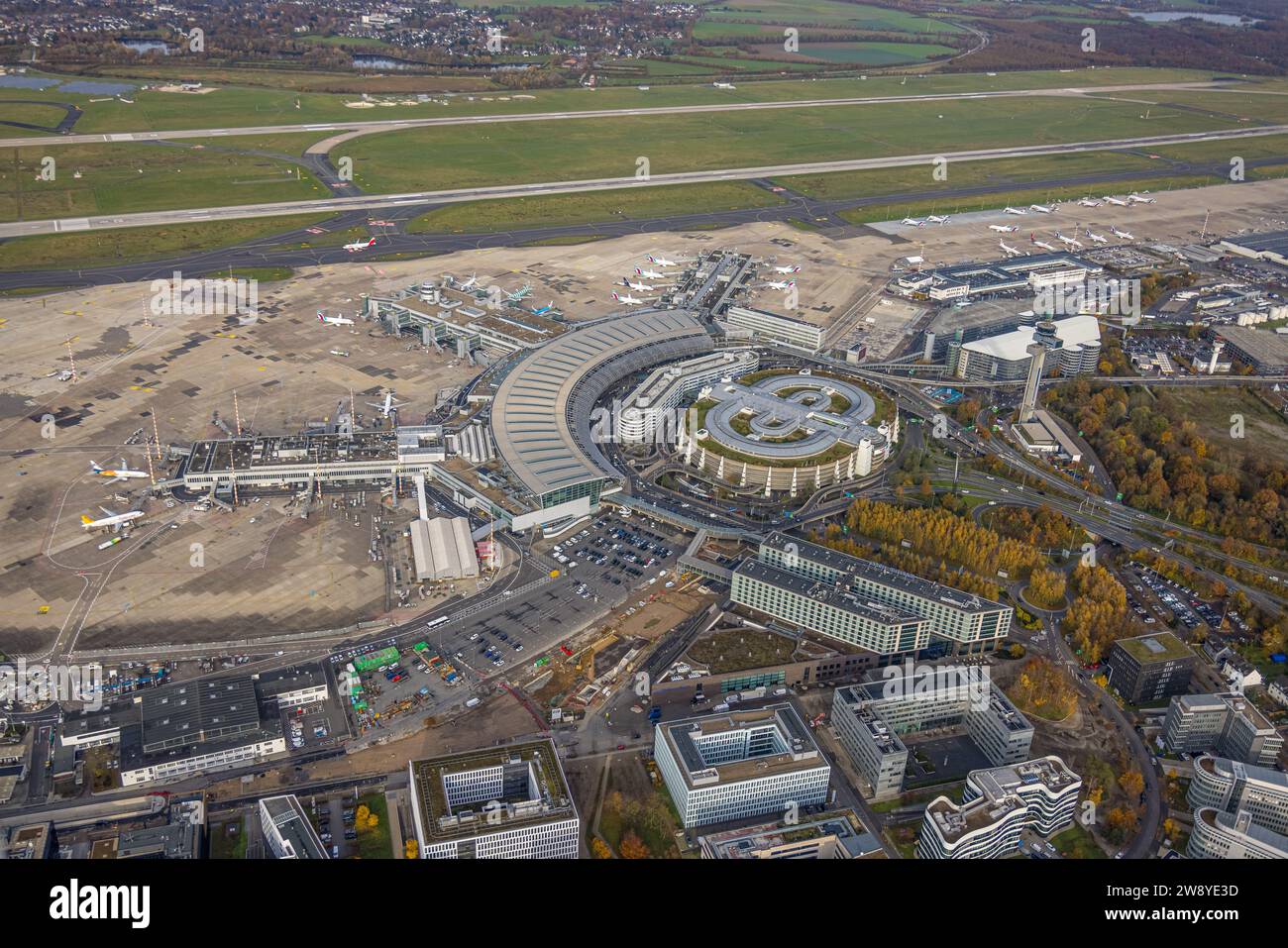 Luftaufnahme, Flughafen Düsseldorf, Terminals und Empfangshalle und Flugzeuge, umgeben von herbstlichen Laubbäumen, Lohausen, Düsseldorf, Rheinland, Stockfoto