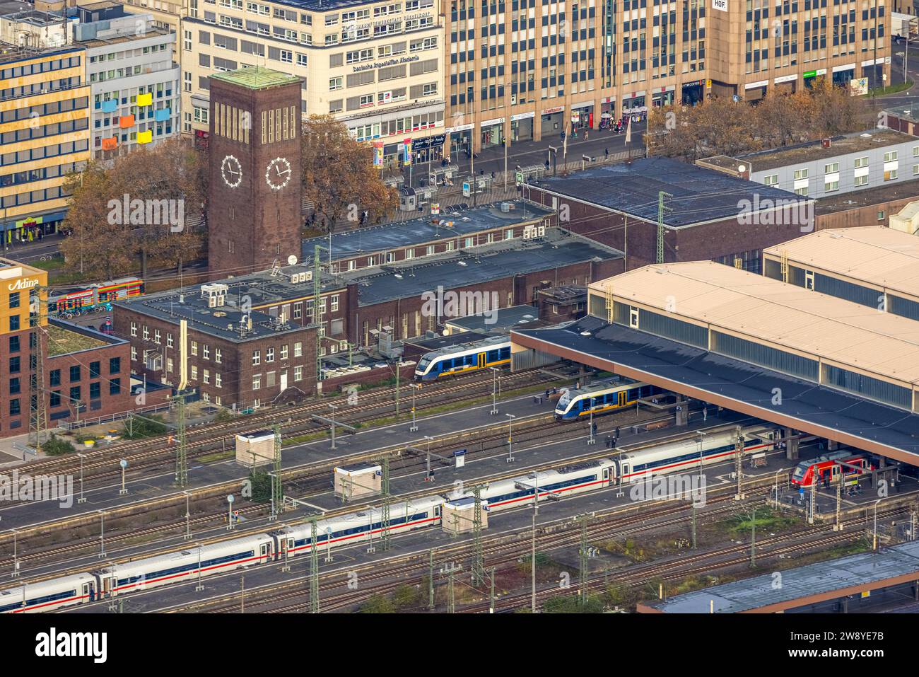 Blick aus der Luft, überdachter Hauptbahnhof Hbf und Bahnhofsgebäude mit Turmuhr, Geschäftsviertel, umgeben von herbstlichen Laubbäumen, Stadtzentrum, Stockfoto