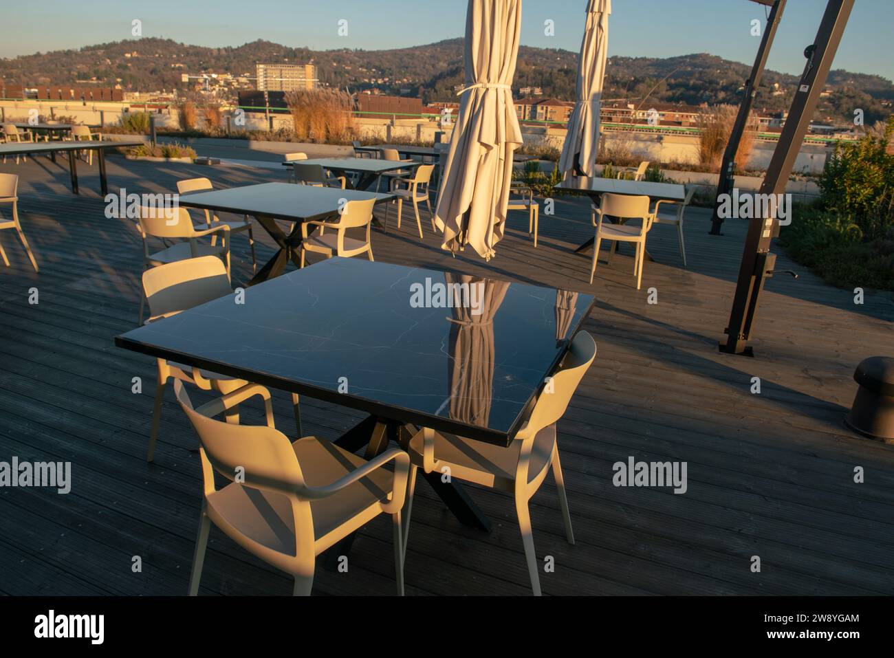 Tische eines Open-Air-Restaurants auf der Terrasse eines Touristenorts, ein Tisch mit modernen Tischen an Feiertagen und Feiertagen, die die meisten Touristen lieben din Stockfoto