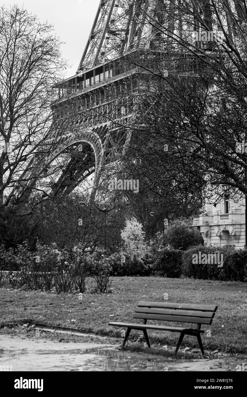Leere öffentliche Bank am Fuße des Eiffelturms in Paris in Schwarz-weiß - Frankreich Stockfoto