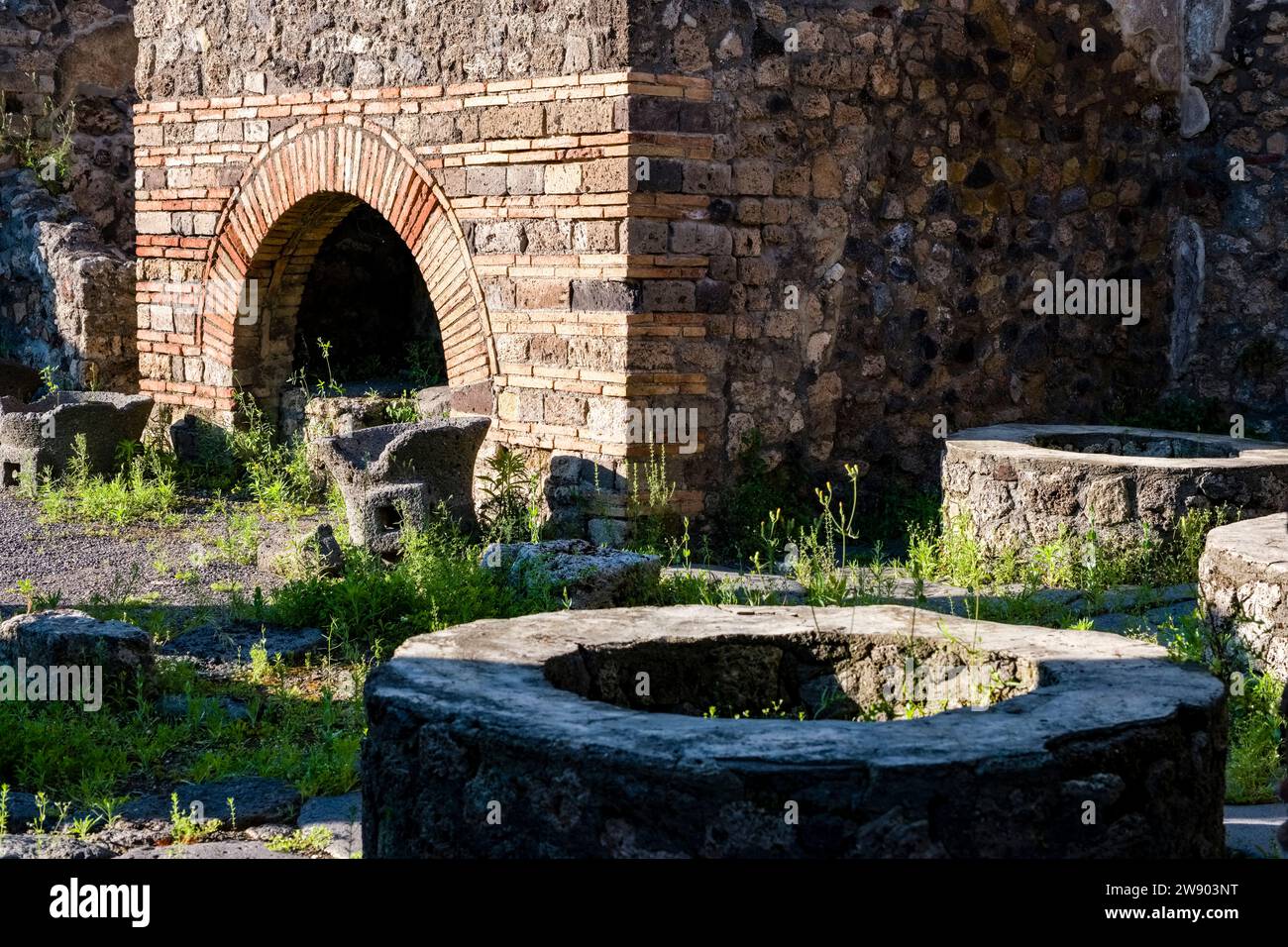 Ruinen des Pistrinums in der archäologischen Stätte von Pompeji, einer antiken Stadt, die durch den Ausbruch des Vesuvs im Jahr 79 n. Chr. zerstört wurde. Stockfoto