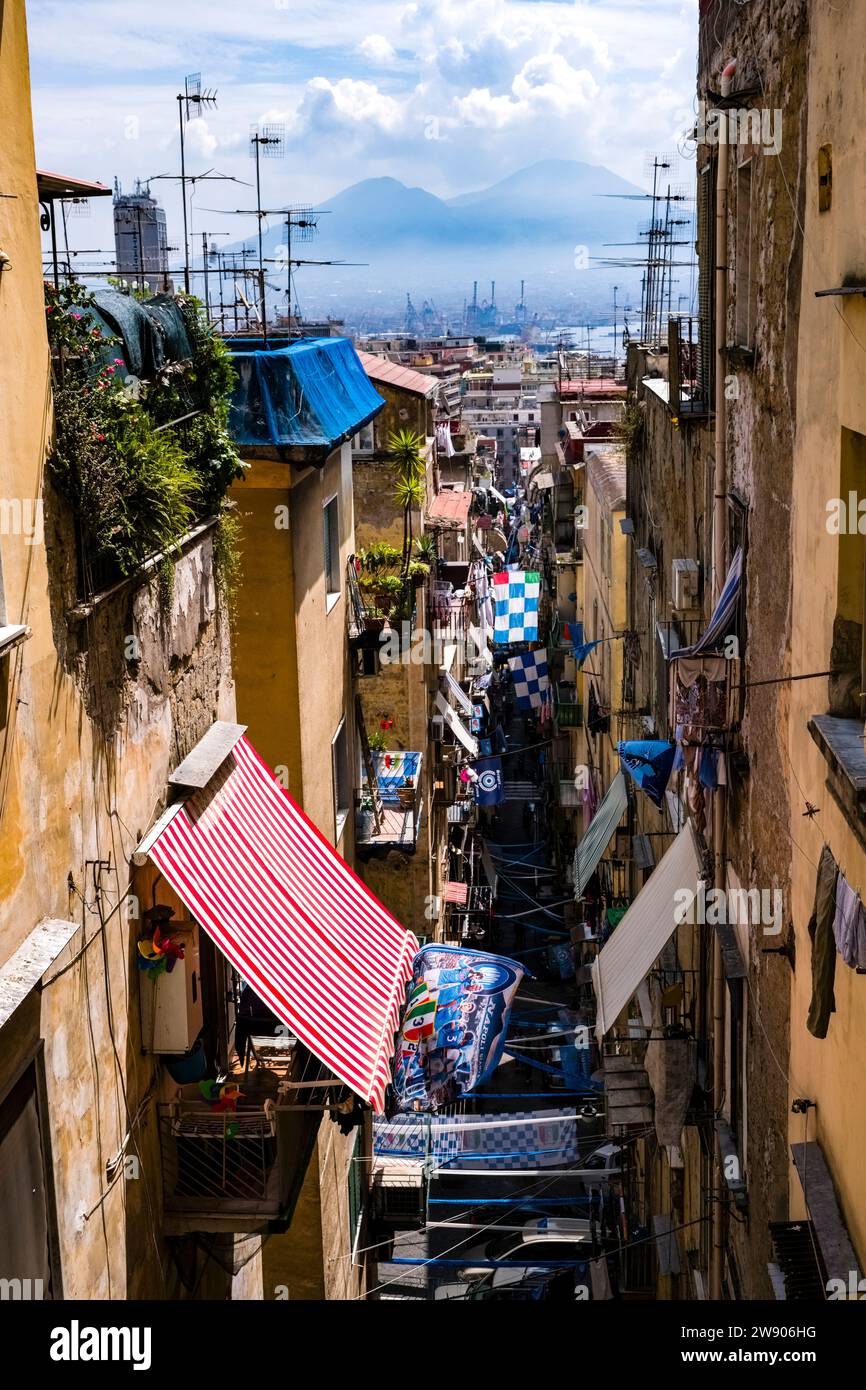 Enge Gasse in der Stadt Neapel mit Balkonen, Sonnenschirmen und mit Fahnen des SSC Neapel verziert, der gerade den italienischen Championshi 2023 gewonnen hat Stockfoto