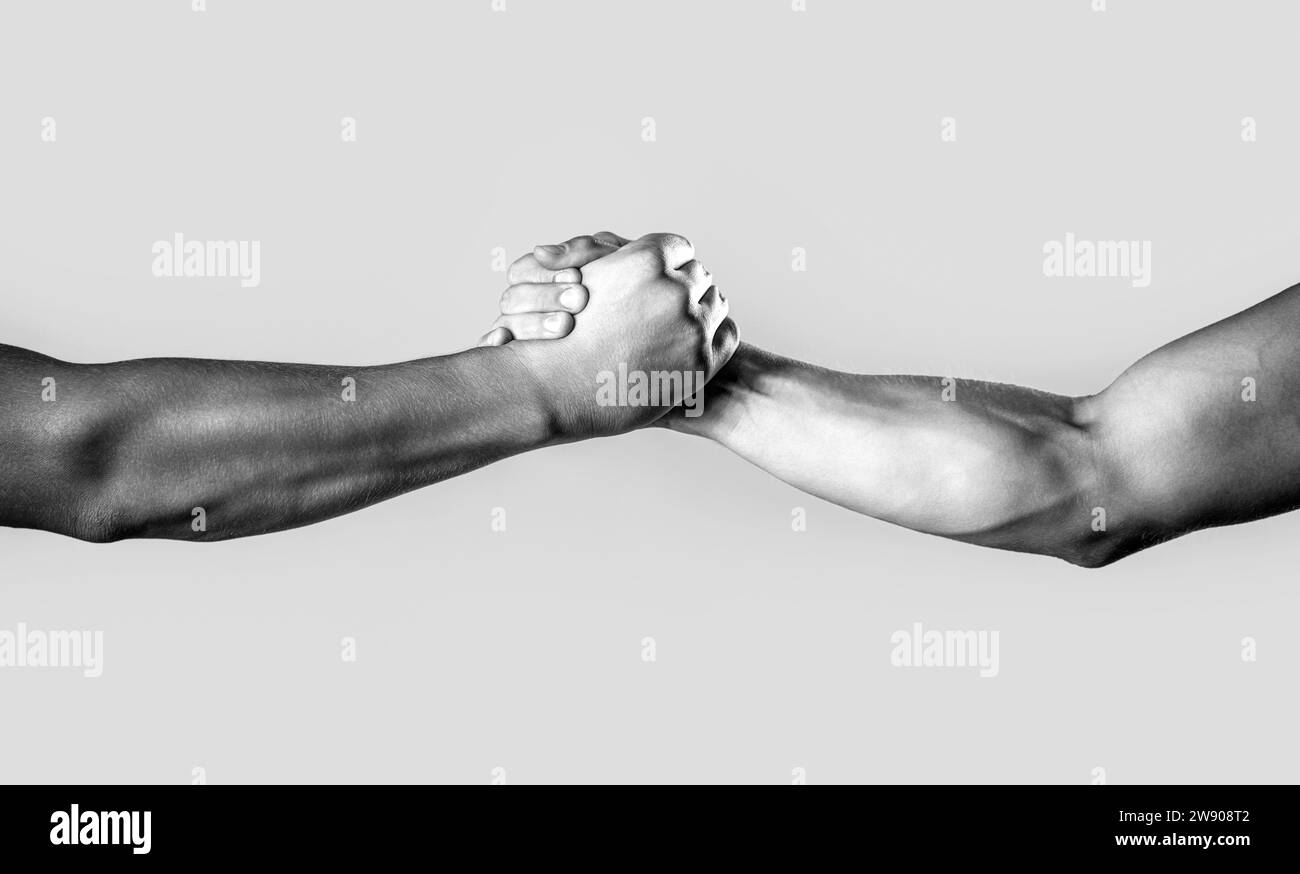 Zwei Hände, helfender Arm eines Freundes, Teamwork. Freundlicher Handschlag, Begrüßung durch Freunde, Teamarbeit, Freundschaft. Nahaufnahme der Hilfeseite. Schwarz-weiß Stockfoto
