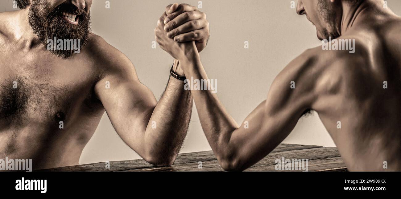 Arme ringen dünne Hand, großer starker Arm im Studio. Zwei Männerhände umklammten Arm Wrestling, stark und schwach, ungleiche Übereinstimmung. Stark muskulös bärtiger Mann Stockfoto
