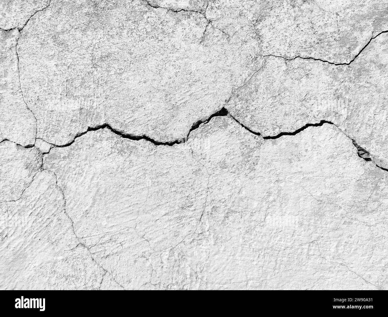 Die Mauer eines alten Gebäudes mit zerbröckelndem Putz und vielen gewundenen, tiefen Rissen. Kopierbereich. Schwarzweißfoto. Selektiver Fokus. Stockfoto Die Mauer eines alten Gebäudes mit zerbröckelndem Putz und vielen gewundenen, tiefen Rissen. Kopierbereich. Schwarzweißfoto. Selektiver Fokus. Stockfoto