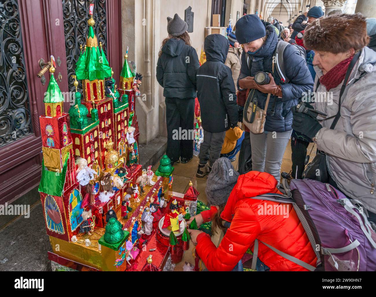 Die Künstlerin vervollständigt ihre Szopka (Weihnachtskrippe), die bei der Eröffnung des jährlichen Wettbewerbs im Dezember in der Liste des UNESCO-Weltkulturerbes in den Arkaden von Sukiennice (Tuchhalle), dem Hauptmarkt in Kraków, Polen, gezeigt wird Stockfoto