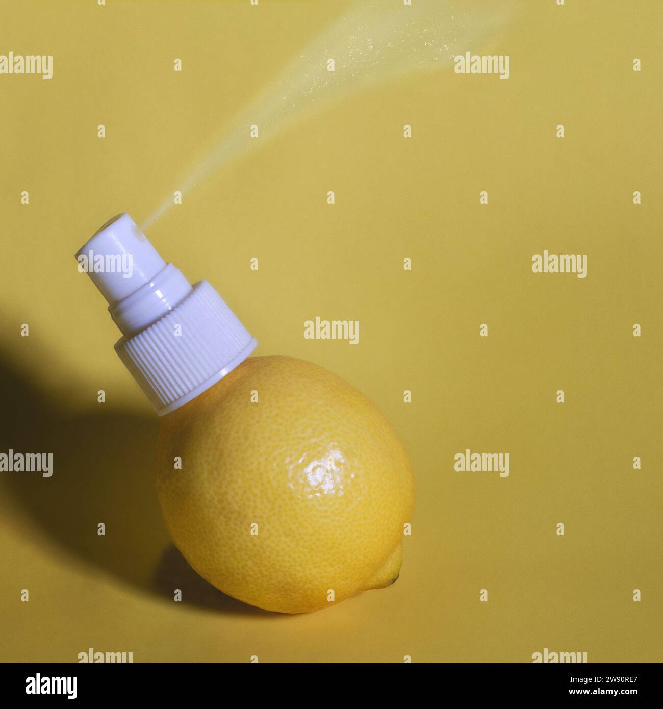 Zusammengesetztes Bild einer Zitrone mit einem Sprühflaschenaufsatz, der einen Duft in die Luft sprüht. Stockfoto