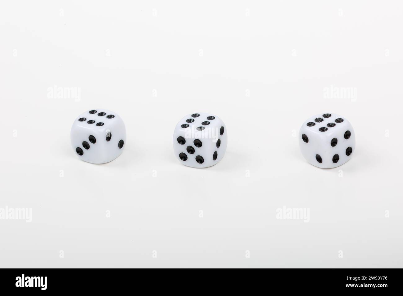 Set aus drei weißen Würfeln mit sechs Punkten auf weißem Hintergrund - perfekt für Brettspiele und Casino-Nächte Stockfoto