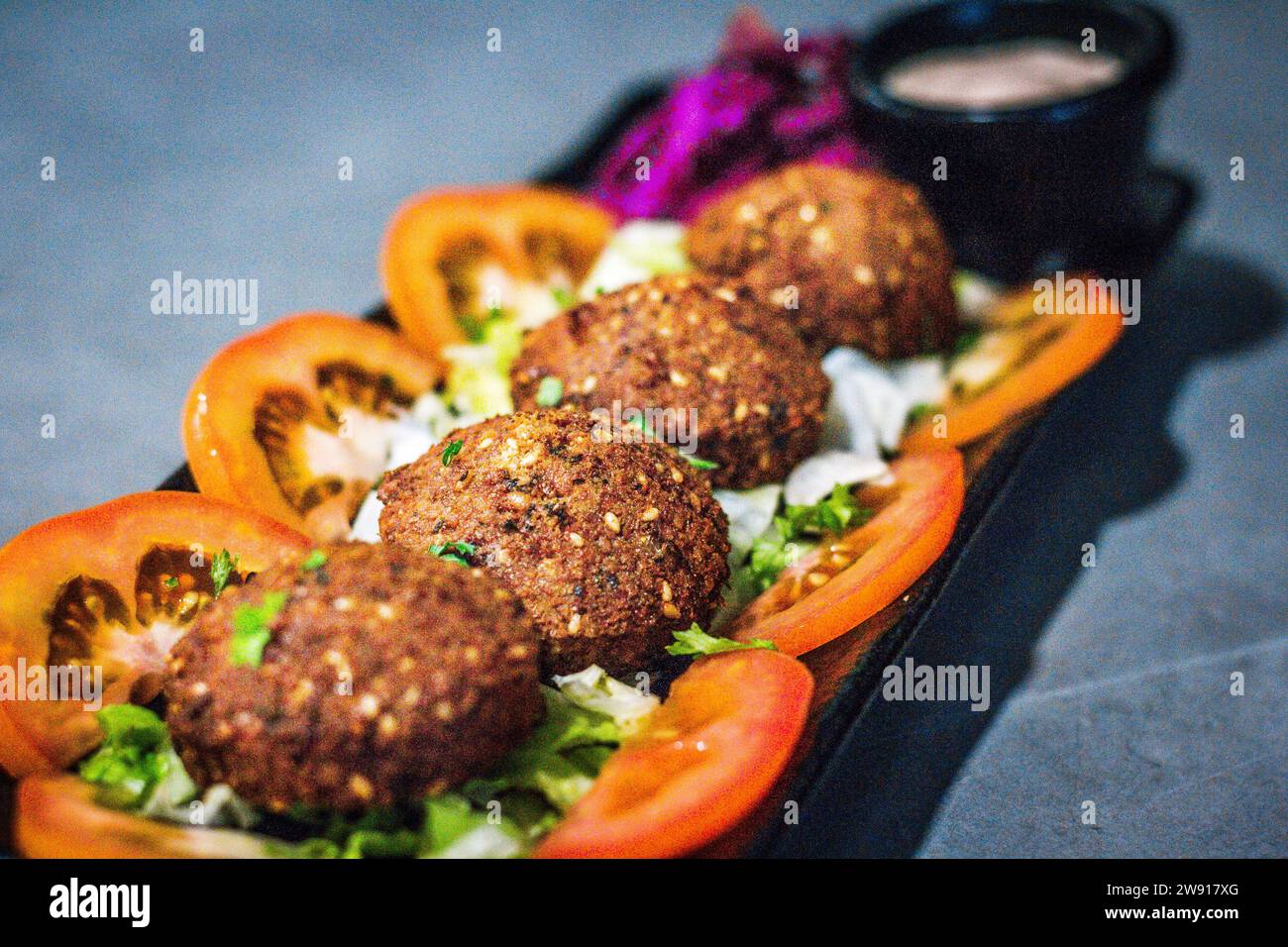 Eine Portion heiße Mezza – Falafel serviert mit Tomaten, Salat und Rotkohl Stockfoto