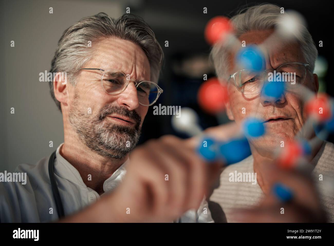 Leitender Wissenschaftler, der mit dem Menschen über die Molekularstruktur diskutiert Stockfoto