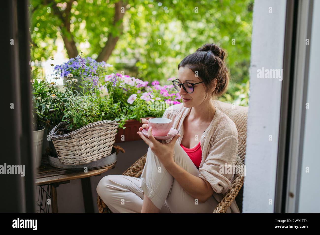 Frau genießt ihre Freizeit und eine Tasse Kaffee auf dem Balkon Stockfoto