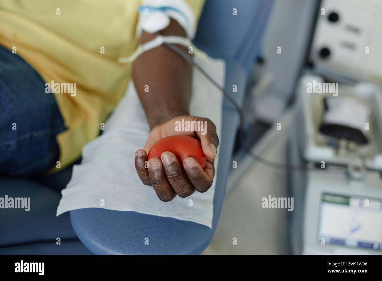 Die Hand des Mannes drückt den Ball in der Hand im Blutspendezentrum Stockfoto