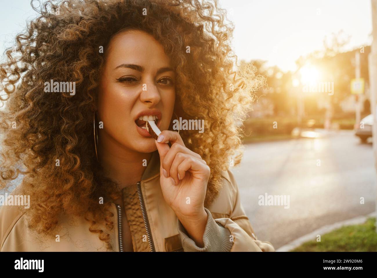 Schöne Frau mit Löffel im Mund auf der Straße Stockfoto