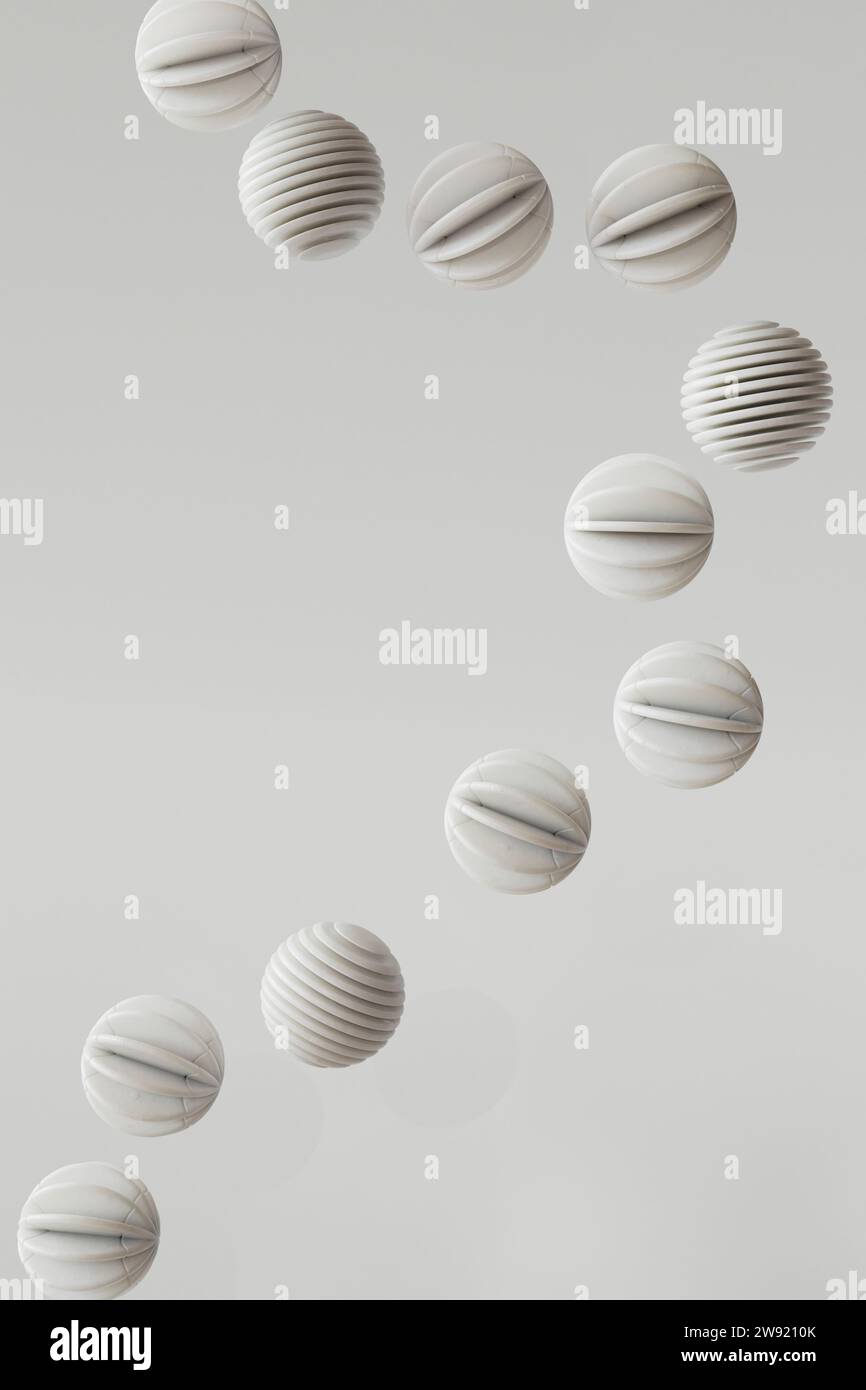 3D-Rendering einer Reihe von gestreiften Kugeln, die vor weißem Hintergrund schweben Stockfoto