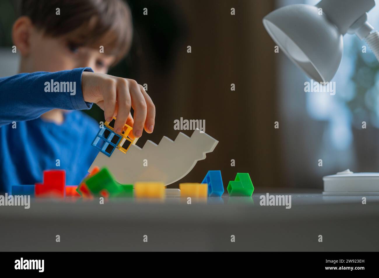 Junge, der Spielzeugblöcke zu Hause balanciert Stockfoto