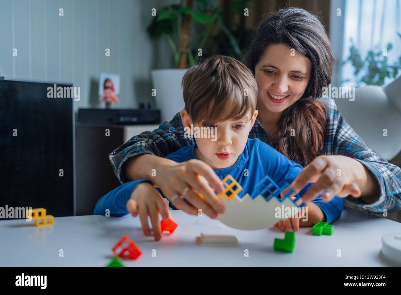 Mutter und Sohn spielen zu Hause mit Spielzeugblöcken Stockfoto