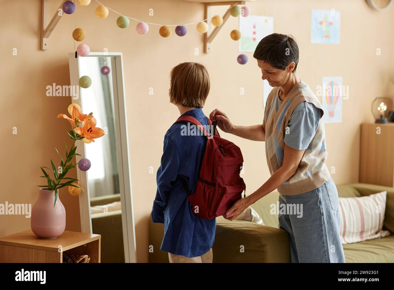 Frau, die ihrer Tochter bei der Schulvorbereitung zu Hause hilft Stockfoto