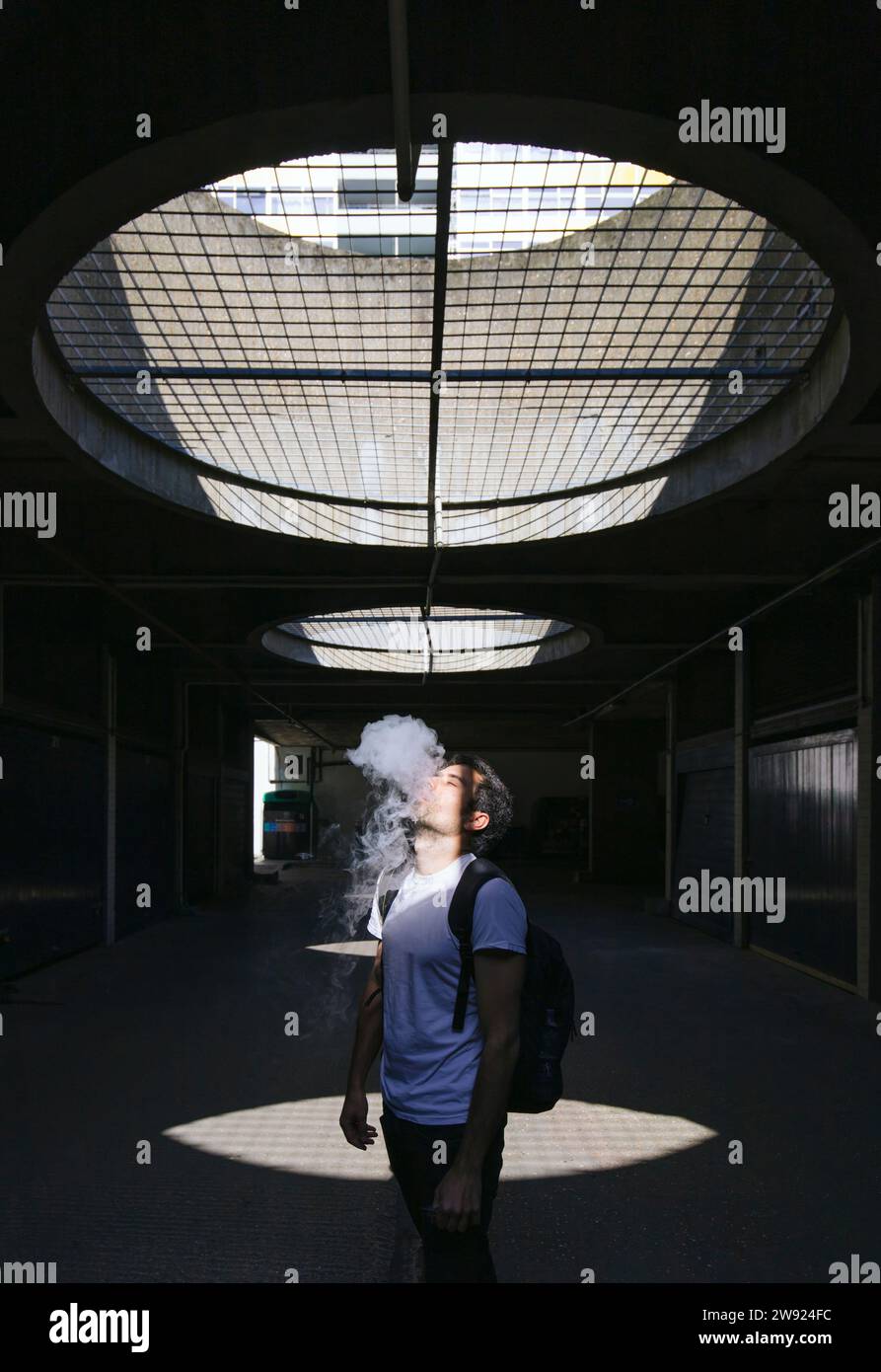 Mann raucht auf unterirdischem Fußweg Stockfoto