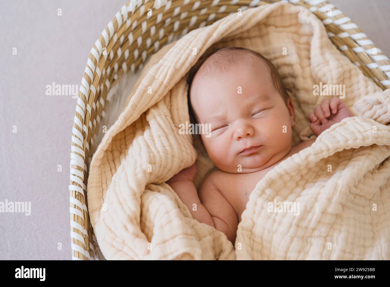 Neugeborener Junge, der im moses-Korb schläft Stockfoto