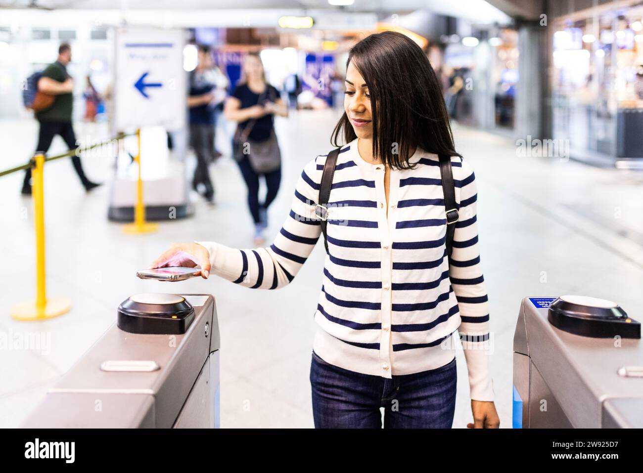 Lächelnde Frau, die Tickets an der U-Bahn-Station scannt Stockfoto