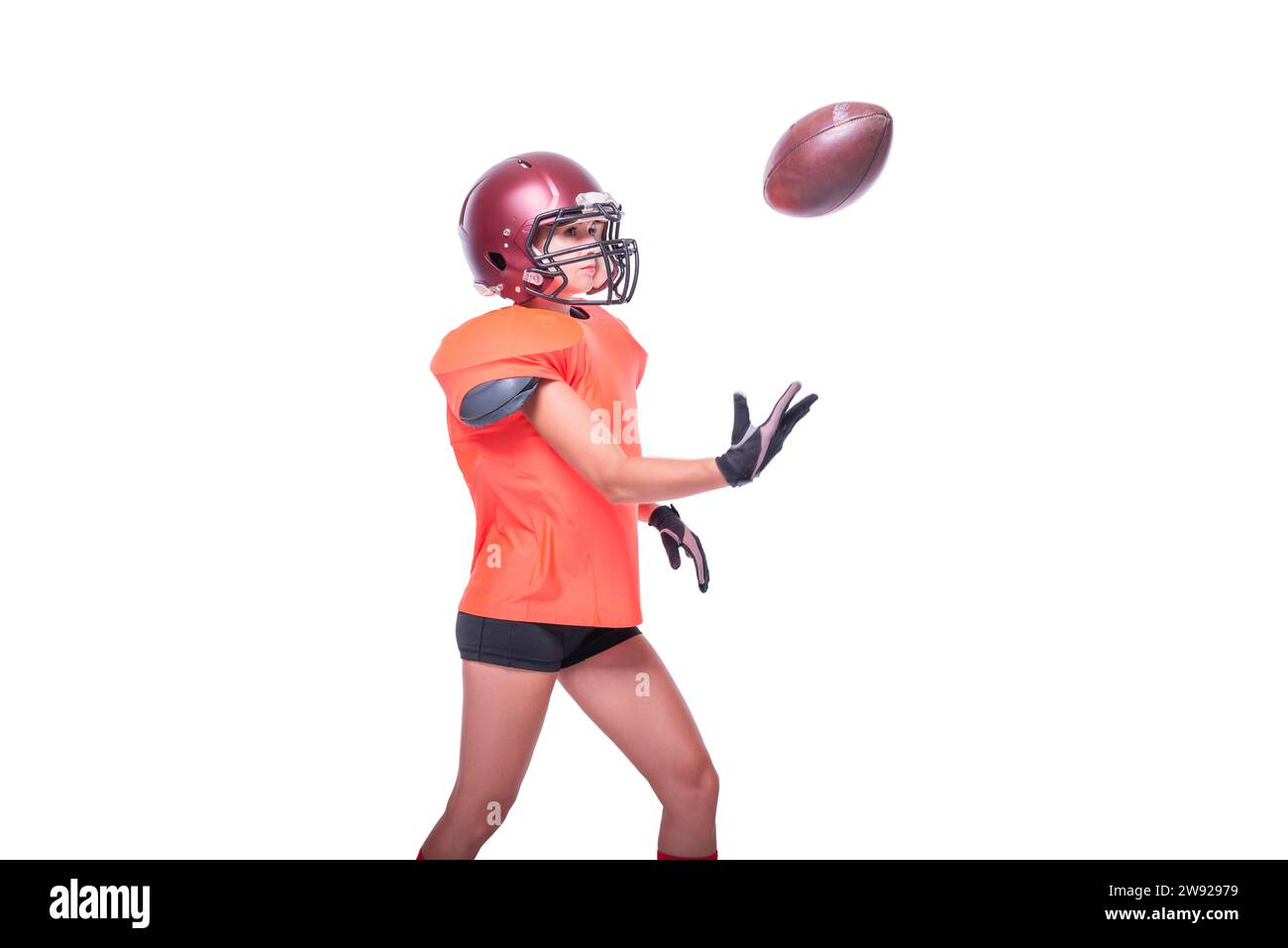 Eine Frau in der Uniform eines American Football-Mannschaftsspielers fängt den Ball. Weißer Hintergrund. Sportkonzept. Gemischte Medien Stockfoto