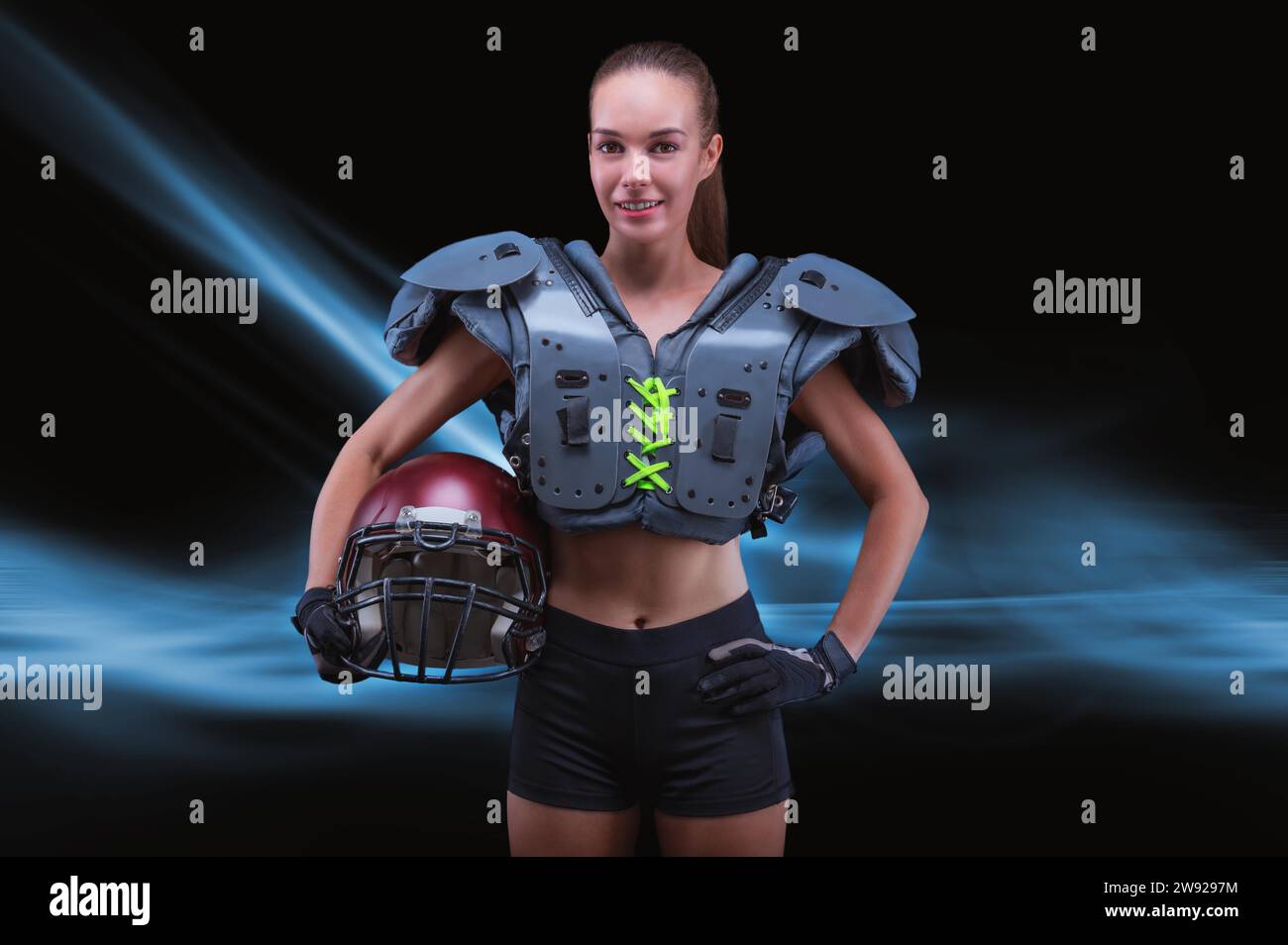 Porträt eines sportlichen Mädchens in der Uniform eines American Football-Mannschaftsspielers. Sportkonzept. Futuristischer Hintergrund. Gemischte Medien Stockfoto