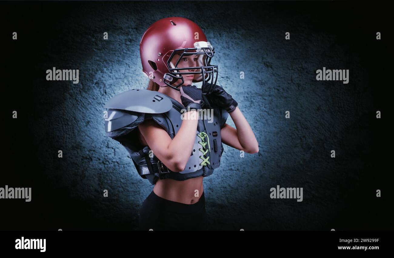 Brutales Porträt eines Mädchens in Uniform eines American Football-Mannschaftsspielers. Gerätewerbung. Sportkonzept. Schulterpolster. Gemischte Medien Stockfoto