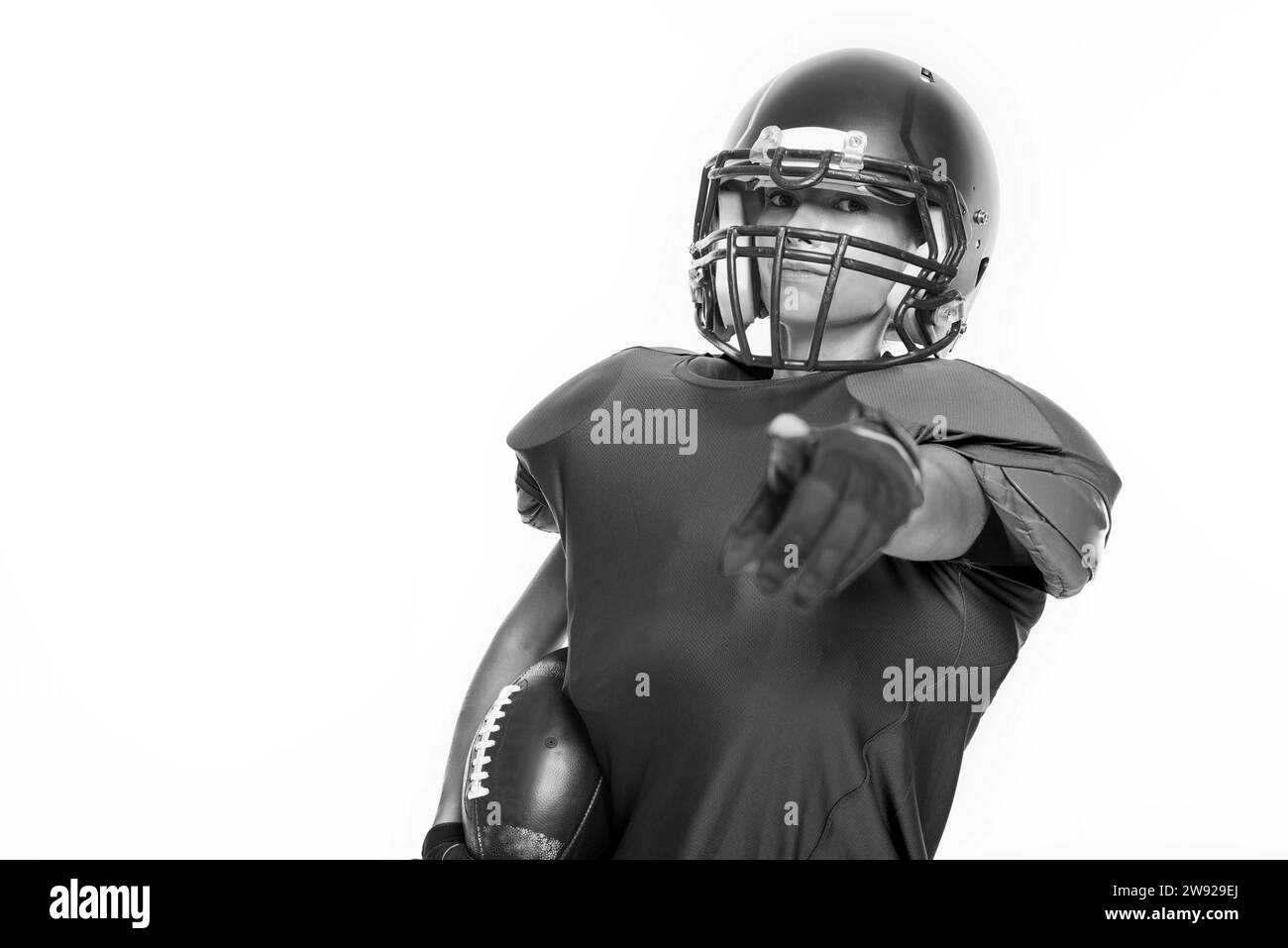 Schwarz-weiß-Bilder eines Sportmädchens in der Uniform eines American Football-Mannschaftsspielers. Sportkonzept. Weißer Hintergrund. Gemischte Medien Stockfoto
