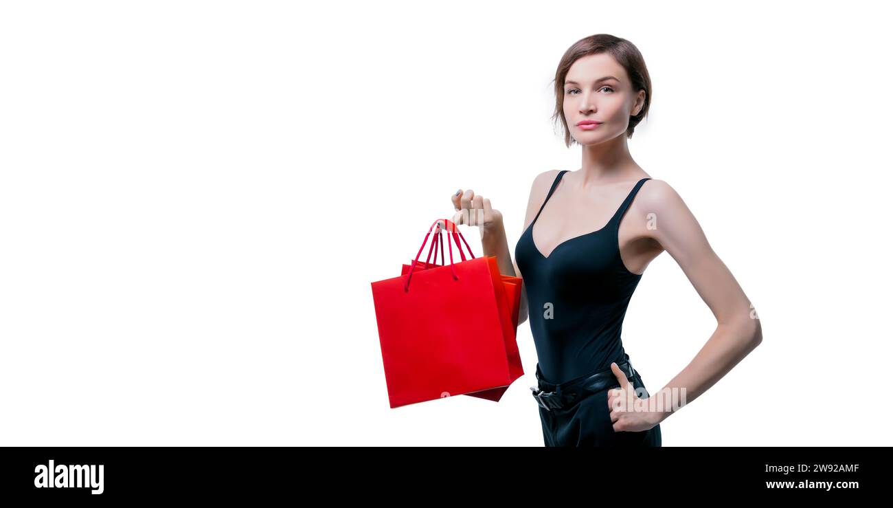 Eine schöne junge Frau, die ein rotes handwerkliches Paket in der Hand hält. Shopaholics-Konzept. Spenting. Geschenke für die Feiertage. Black Friday. Einkaufszentren. Stockfoto