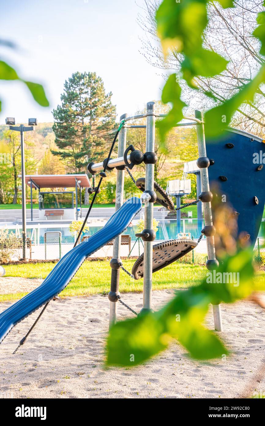 Farbenfrohe Klettergerüst mit Rutsche auf einem Spielplatz inmitten der Natur, Calw Außenpool, Stammheim des Calw Stadtwerks, Black Stockfoto