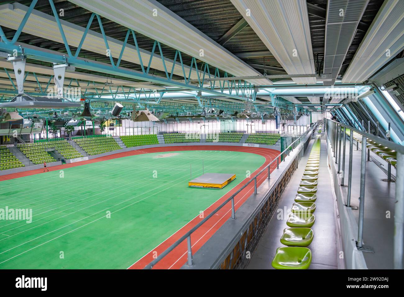 Umfassende Innenansicht einer leeren Sporthalle mit grünen Sitzreihen und Sportplatz, Glaspalast Sindelfingen, Deutschland Stockfoto