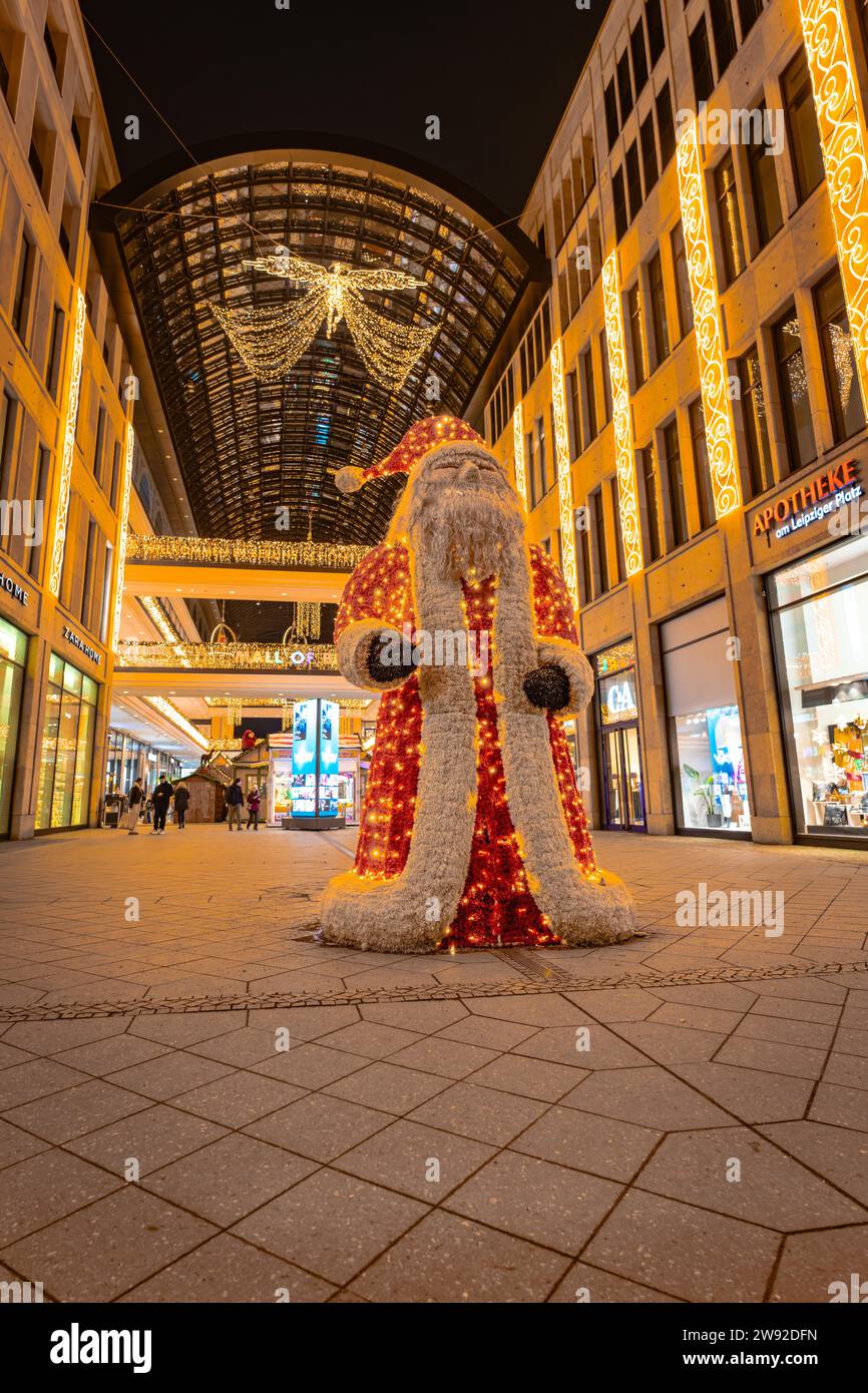 Fußgängerzone bei Nacht mit einem großen beleuchteten Weihnachtsmann und dekorierten Geschäften, Mall of Berlin, Berlin, Deutschland Stockfoto