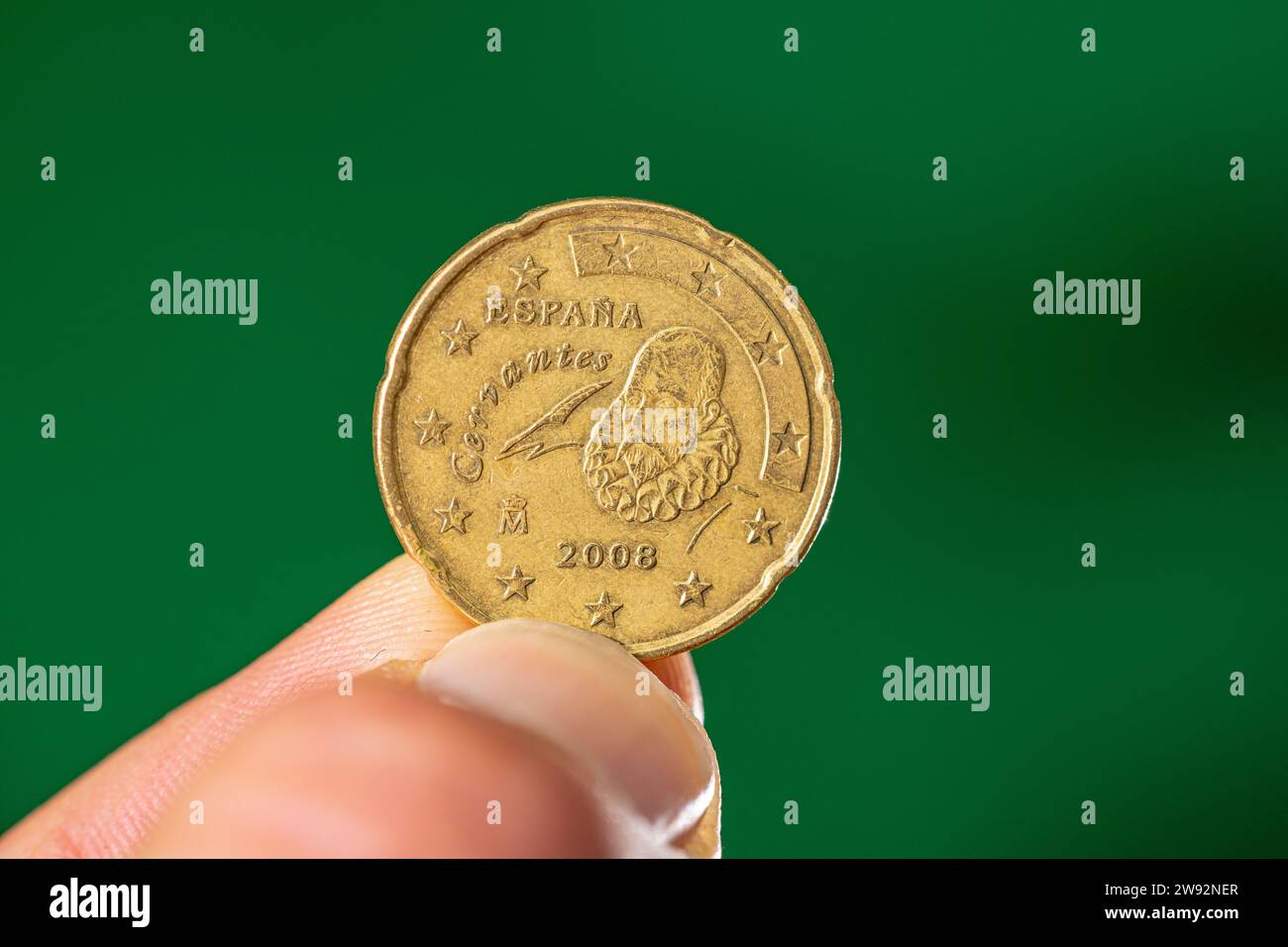 Münzkrone von 20 Eurocent mit der spanischen Darstellung von Cervantes zwischen Daumen und Zeigefinger. Stockfoto