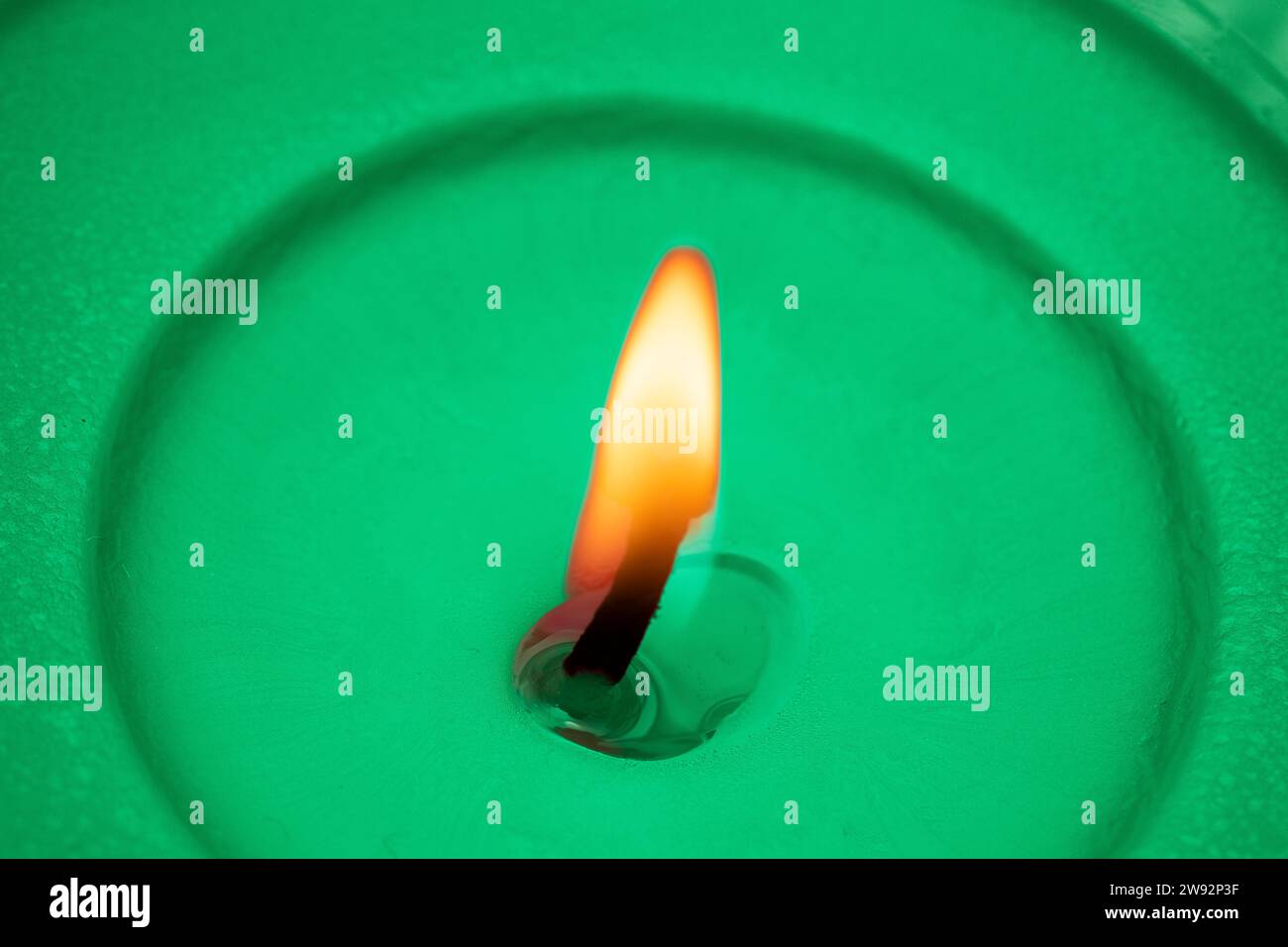 Grüne Wachskerze mit brennender Flamme Stockfoto