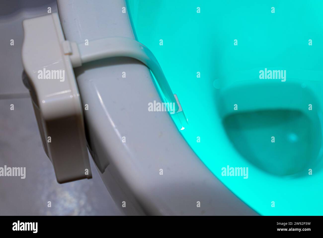 Toilette mit blauem Licht innen durch ein Gerät an der Kante beleuchtet Stockfoto