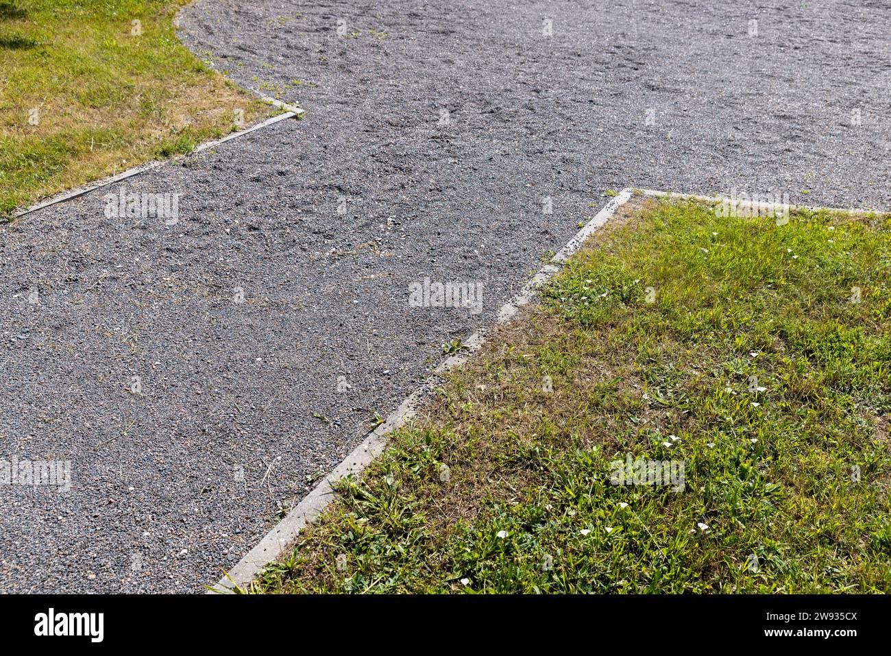 Teil eines Gehwegs, der mit kleinen Schutt und Steinen bestreut ist, ein ökologischer Parkweg zum Spazierengehen Stockfoto
