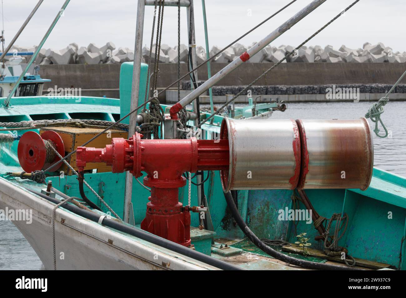 Farbenfrohe Walzen und kommerzielles Fischerboot im Hafen Stockfoto