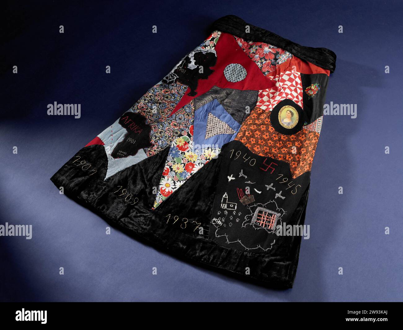 Nationalfeiertag, 1945–1960, machte einen Nationalfeierrock im Rahmen der Befreiung der Niederlande, um an Nationalfeiertagen und in Erinnerung an verschiedene Ereignisse während des Zweiten Weltkriegs zu tragen. Der Rock besteht aus einem orangefarbenen Gürtel und einem schwarzen Gürtel. Auf dem Rock selbst sind verschiedene Ereignisse dargestellt, wie: 1948 - 50 Jahre Wilhelmina (mit Porträt), 1940 - 1945 mit Flugzeugen und Vögeln, ein Gefängnis mit Stacheldraht und eine Kirche mit Friedhof, Karte der Niederlande und Karte von Südafrika mit dem Schiff zwischen dem Gelderland, mit dem Paul Kruger in die Niederlande segelte und die Daten 190 Stockfoto