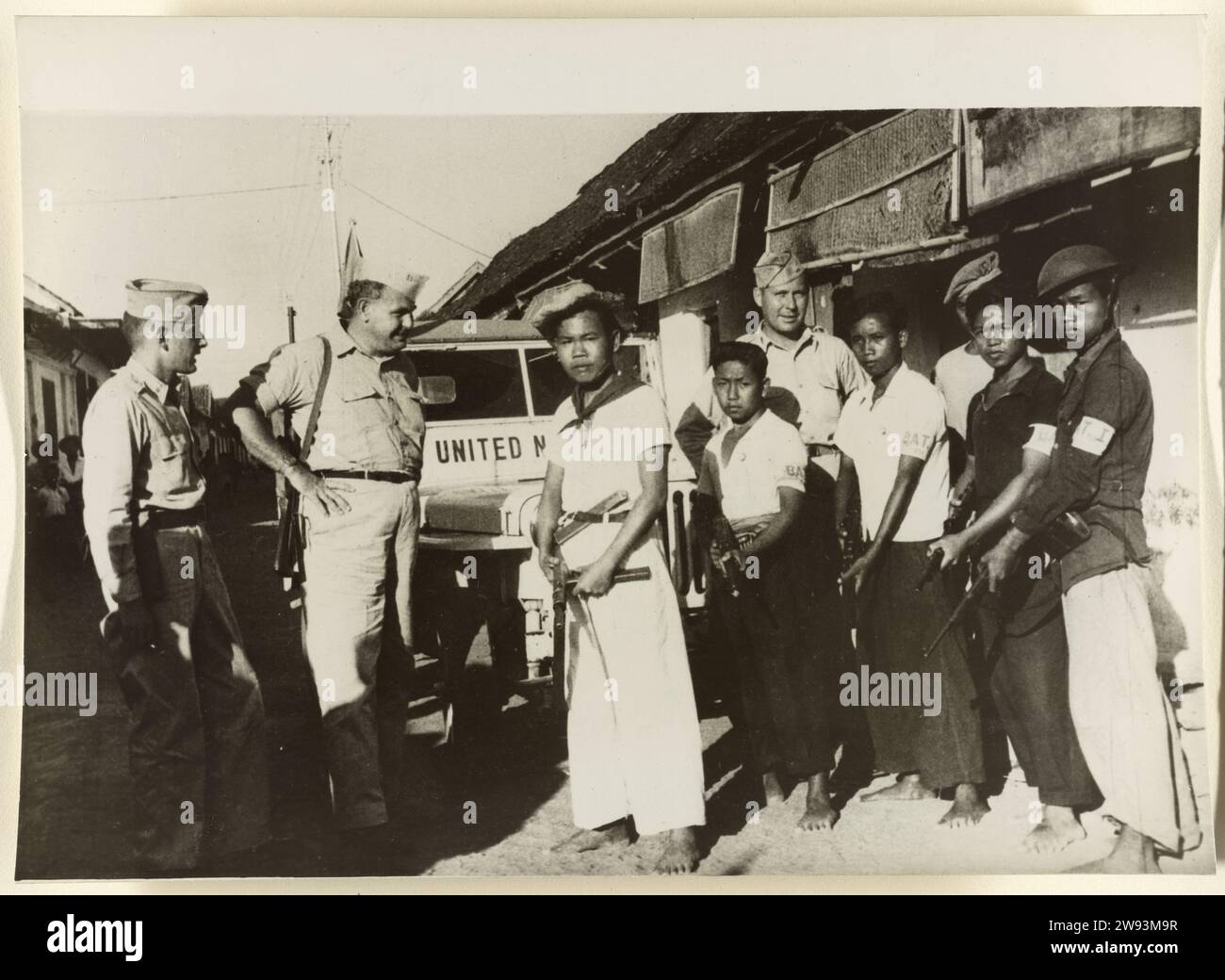 Republikanische Guerillas übernehmen das Dorf Kotagede, 1948–1949 Dokumentarfotos drei Militärbeobachter der Vereinten Nationen und eine Gruppe republikanischer Soldaten befinden sich in einer Straße in Kotagede mit einem UN-Jeep im Hintergrund. Indonesien fotografische Unterstützung Indonesiens Stockfoto