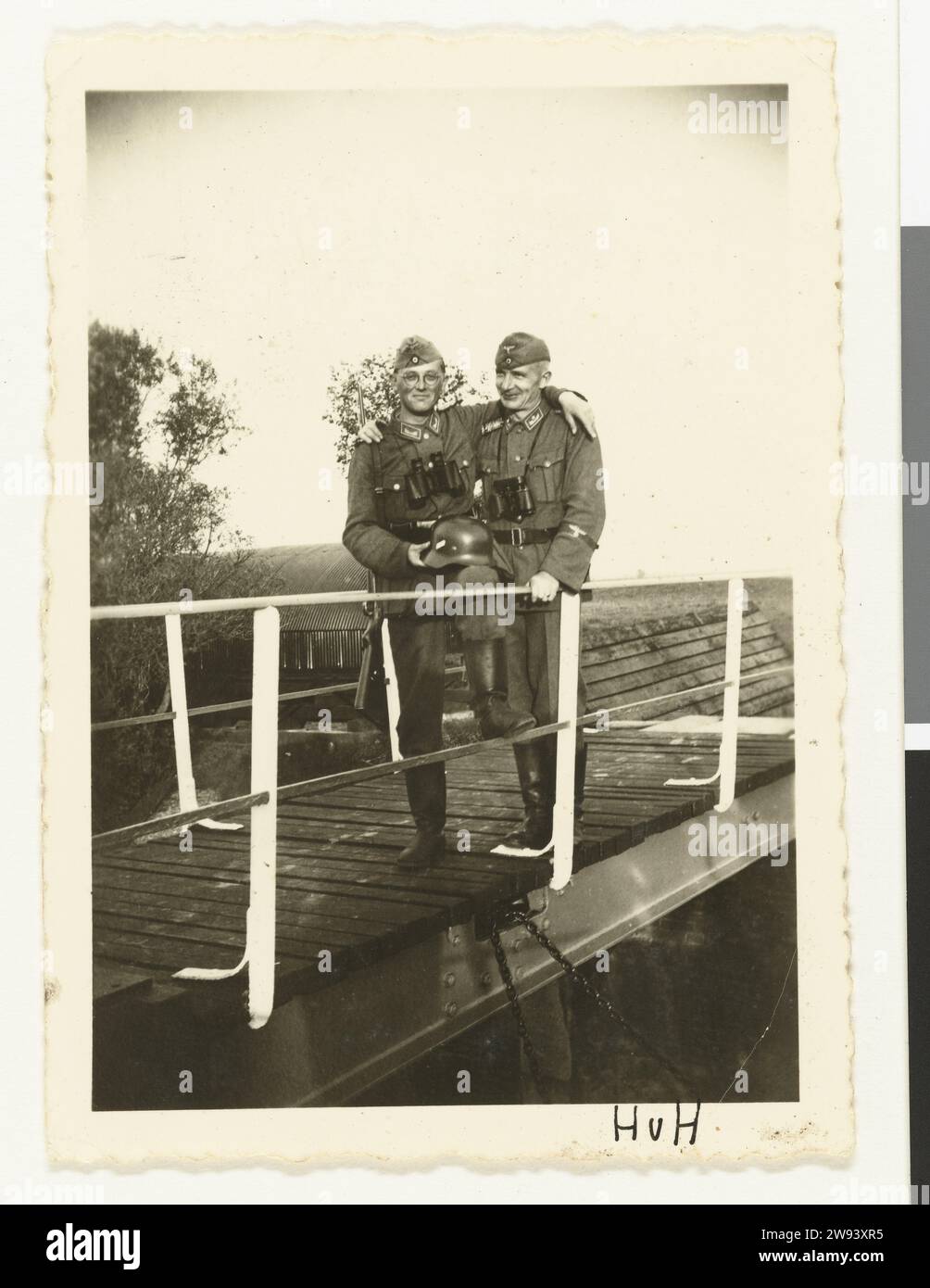 Zwei Wehrmachtssoldaten auf einer Brücke, 1940–1941 Foto zwei Wehrmachtssoldaten wurden auf einer Brücke bei Hoek van Holland fotografiert. Sie tragen Armeeblitter, aber einer hat auch einen Helm in der Hand und trägt eine Brille. Beide haben ein Fernglas. Hoek van Holland fotografische Unterstützung Gelatine Silberdruck Besetzung  Krieg. Der Soldat, das Leben des Soldaten Hoek van Holland Stockfoto