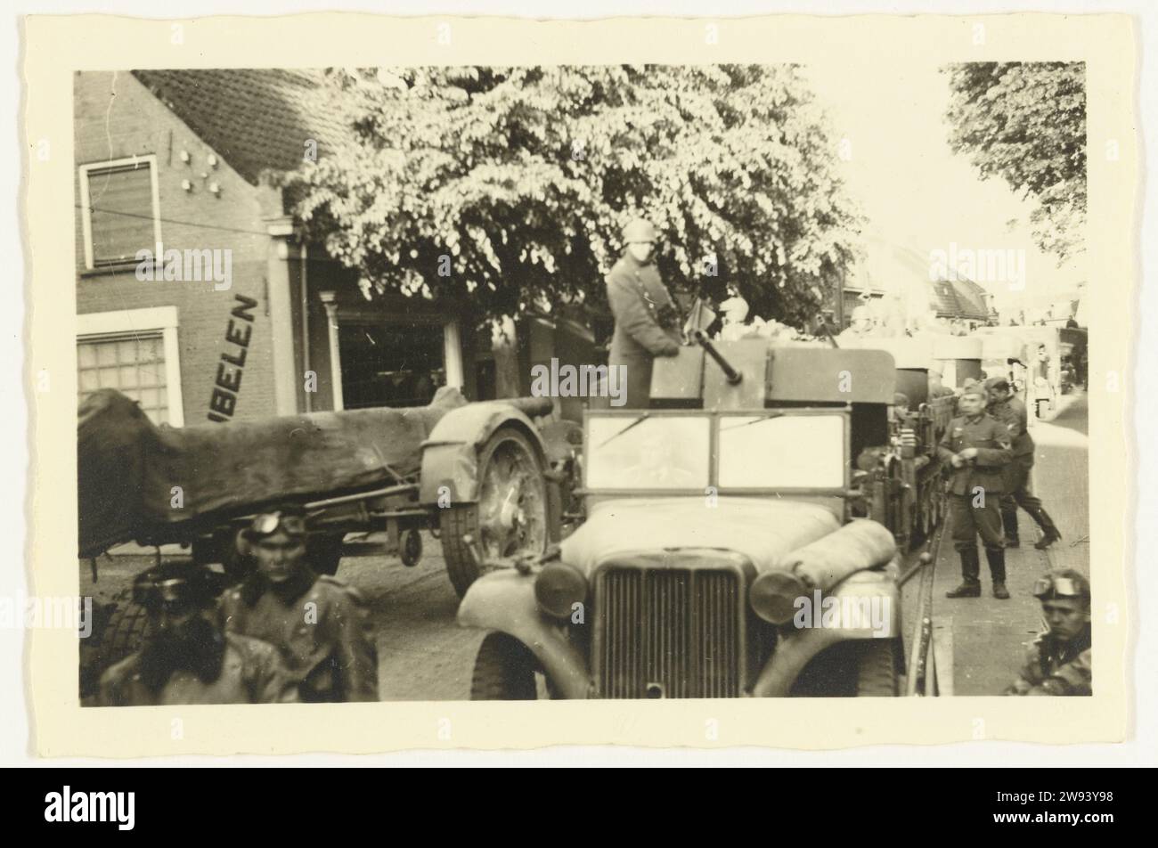 Wehrmacht reist durch die Niederlande, 1940 Foto die Wehrmacht fährt mit gepanzerten Autos in eine niederländische Stadt oder ein niederländisches Dorf. Vor einem Auto mit Waffen, neben ihm eingewickelt. Die Quelle ist auf den Bäumen zu sehen. Niederlande fotografische Unterstützung Gelatine Silberdruck Besetzung  Krieg. Truppenbewegungen, Transport Niederlande Stockfoto