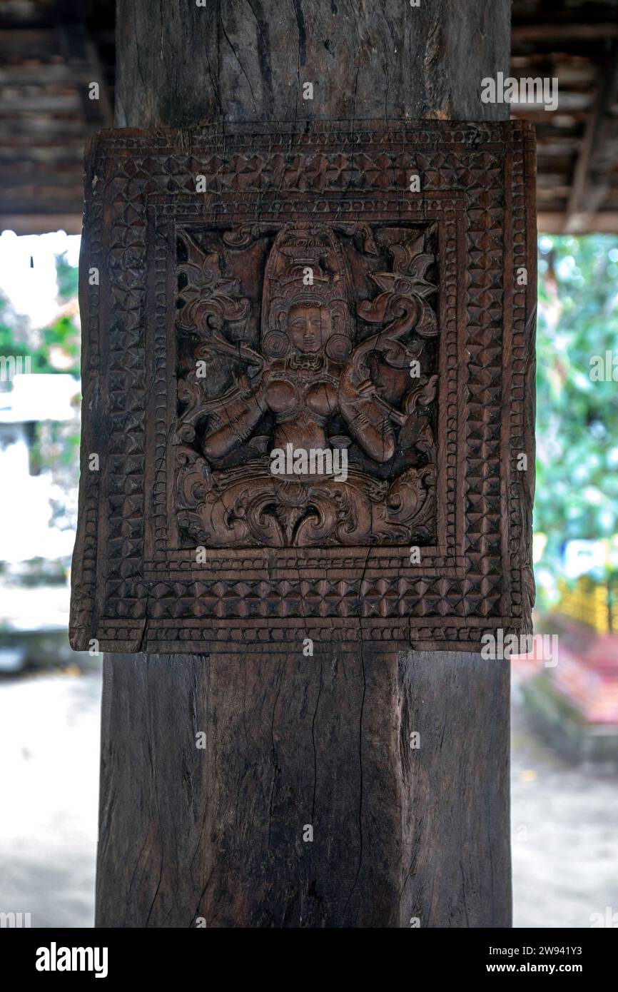 Eine antike Holzschnitzerei auf einer Säule des Grabens (Trommelpavillon), die eine weibliche Figur in Embekke Devalaya in der Nähe von Kandy in Zentral-Sri Lanka darstellt. Stockfoto