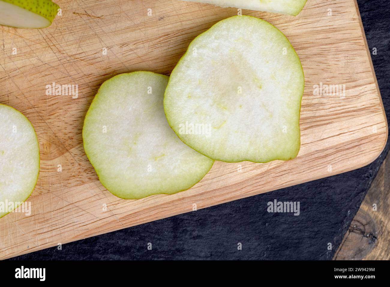 In Scheiben geschnittene reife und saftige grüne Birnen, köstliche Birnen gewaschen und fertig zum Kochen Stockfoto