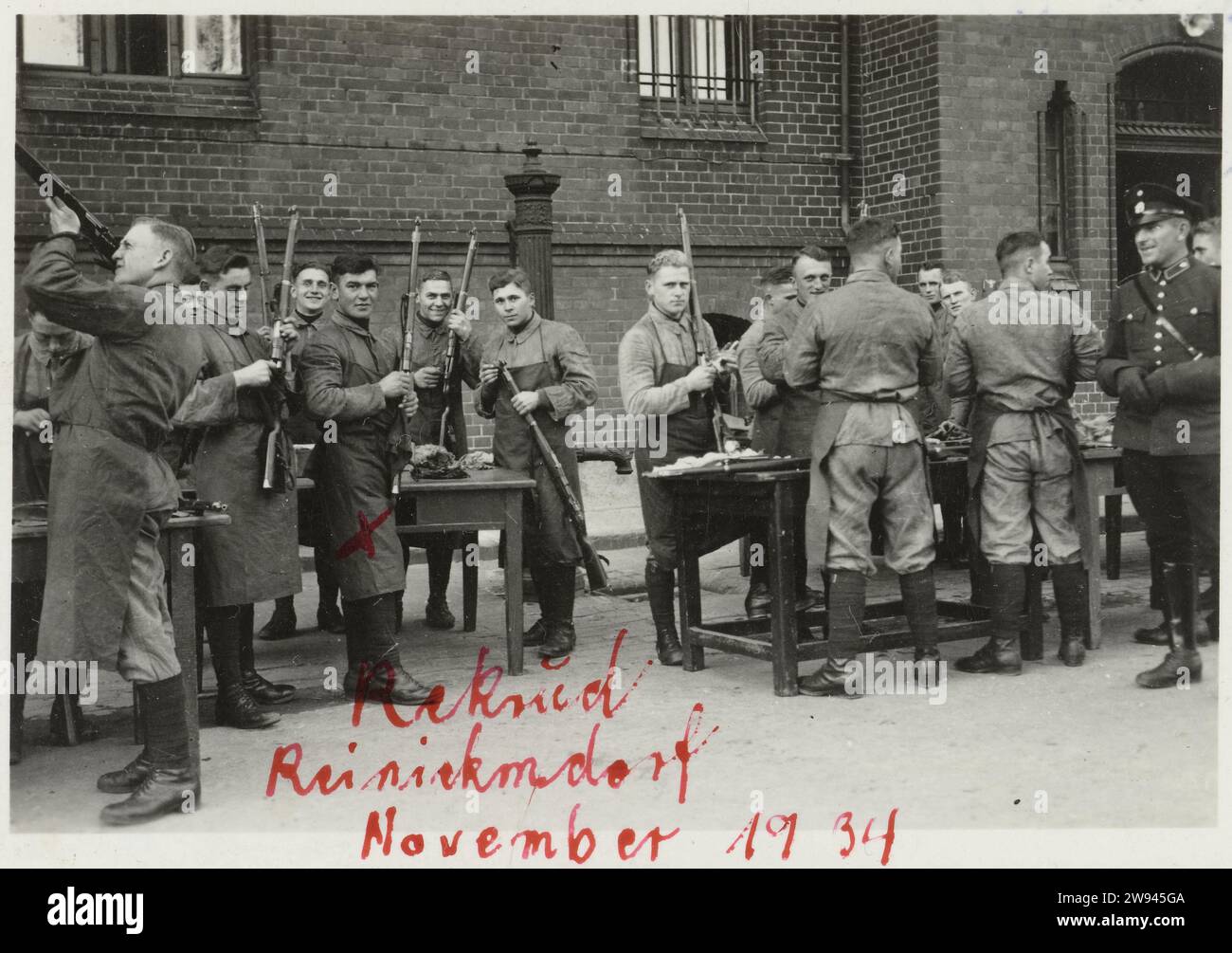 Reinigung der Waffen, 1940 - 1945 fotografieren Sie Eine Gruppe von Wehrmachtssoldaten während ihrer Ausbildung, die damit beschäftigt waren, ihre Waffen zu reinigen. Inschrift: Rekrutenzeit, November 1934, Reinickendorf. Foto zum Album KriegSerinnerungen. Deutschland fotografischer Träger Gelatine Silberdruck Deutschland. Niederlande Stockfoto