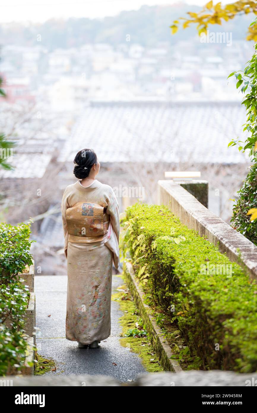 Japanische weibliche Kimono Porträt Rückansicht Fotografie. Kyoto, Japan. Traditionelle japanische Gebäude im Hintergrund. Stockfoto